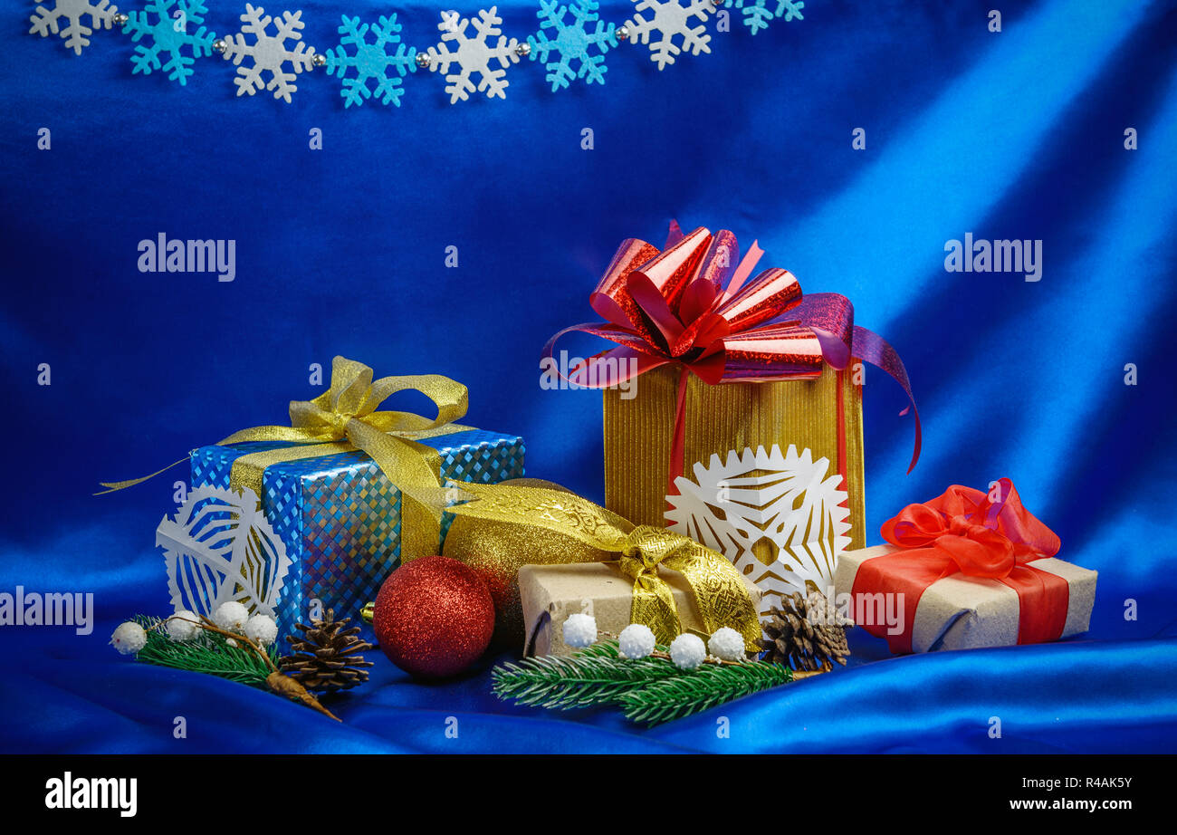 Christmas gift boxes and decorations over blue silk background Stock Photo