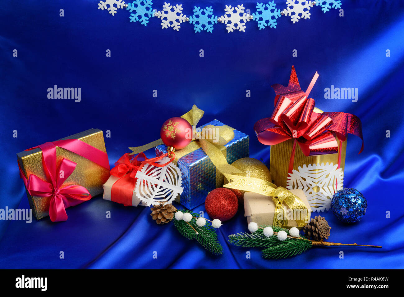 Homemade Christmas gift boxes and decorations over blue silk background Stock Photo
