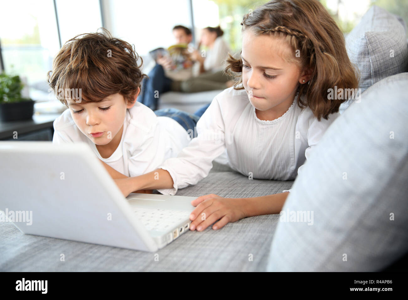 Kids playing with laptop computer at home Stock Photo - Alamy