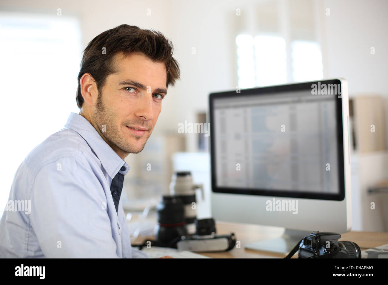 Photographer in office working on desktop computer Stock Photo Alamy