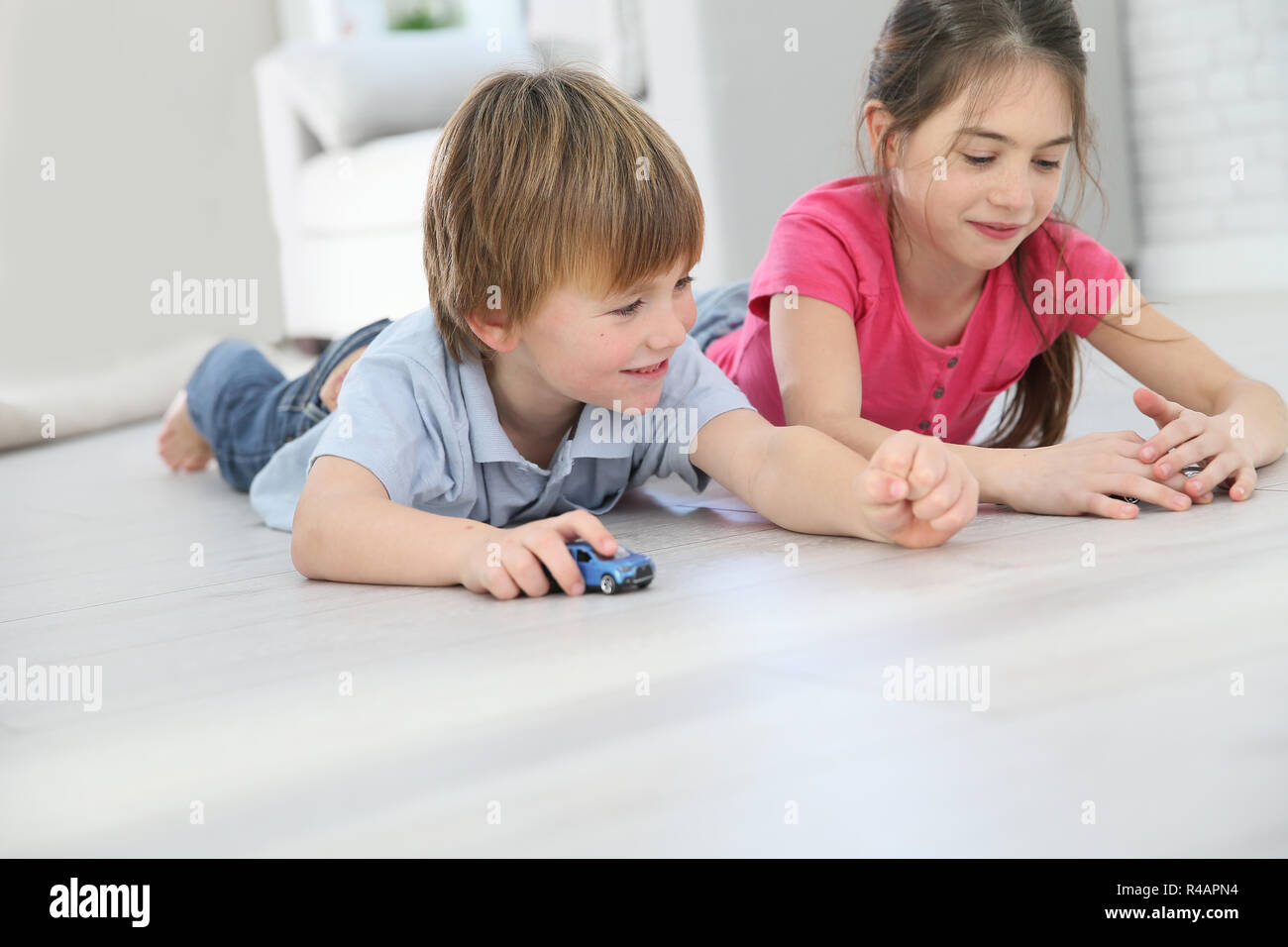 Kids playing with toy cars laying on floor Stock Photo - Alamy