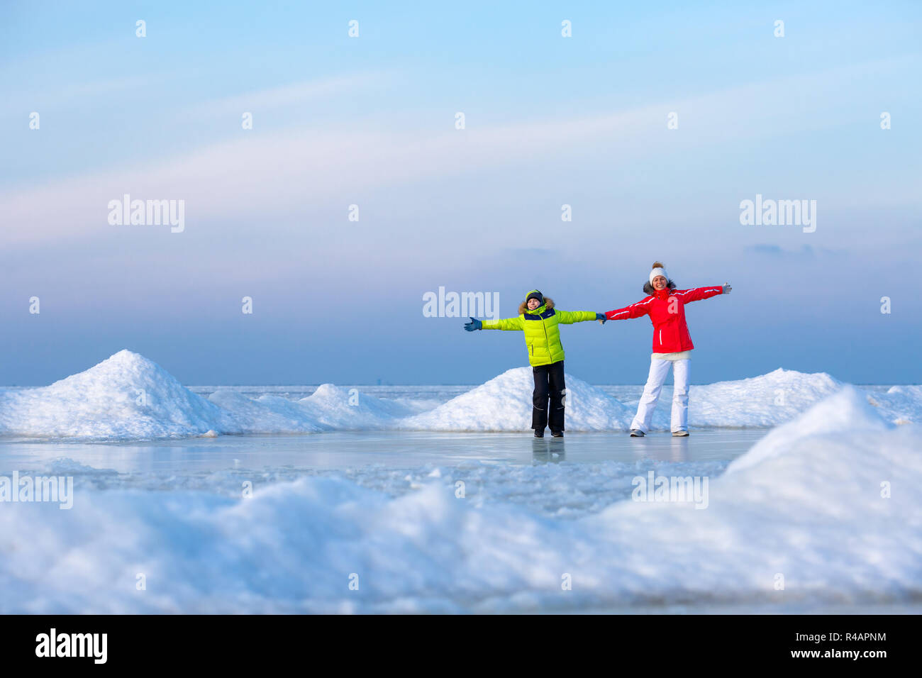 Young mother and her son on icy beach Stock Photo