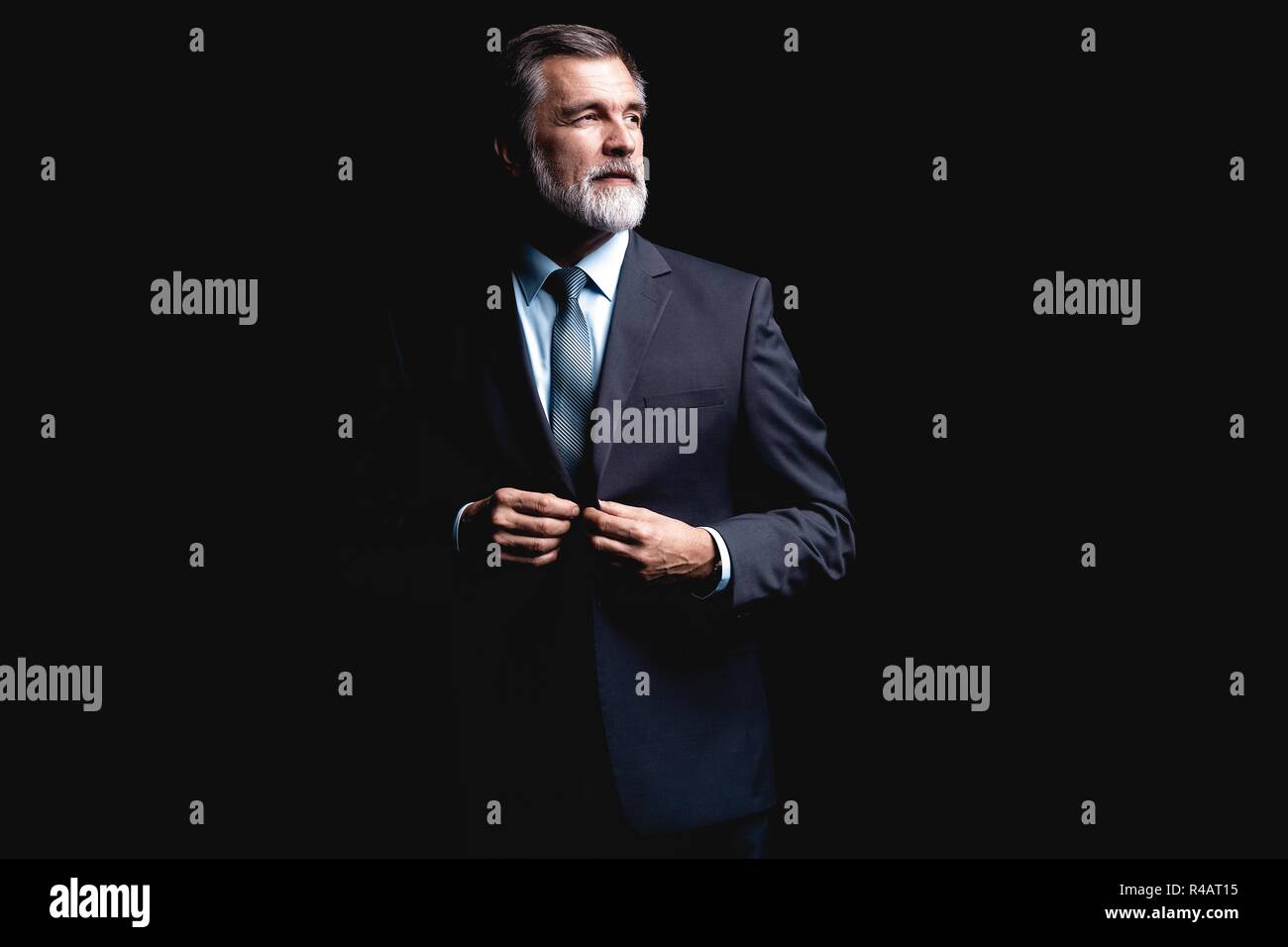 Handsome mature business man isolated on black background Stock Photo