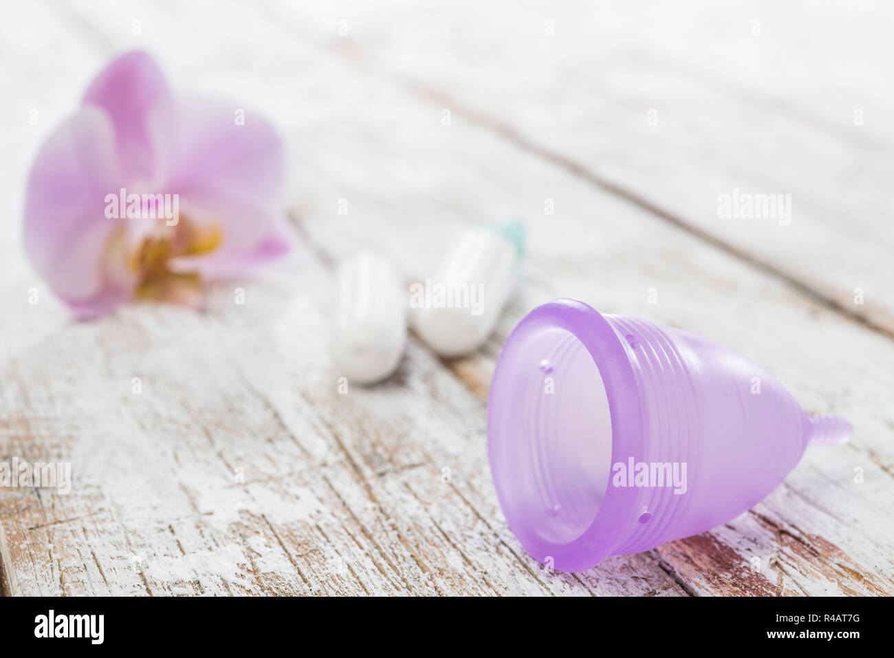 menstrual cup on an old wooden table withe white paint Stock Photo