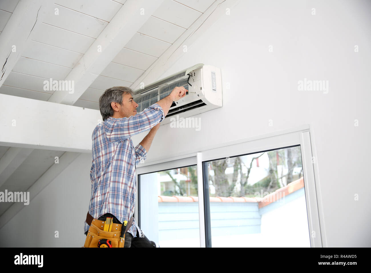 Repairman fixing air conditioner unit Stock Photo Alamy