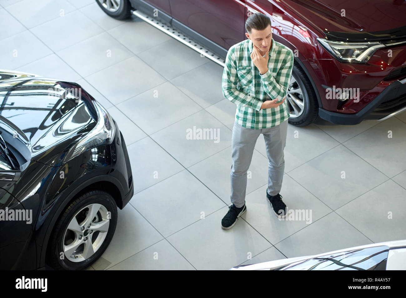 One Owner Car Guy >> Young Man Standing Between Black And Dark Red Cars Guy In Checkered One Owner Car Guy >> Young Man Standing Between Black And Dark Red Cars Guy In Checkered