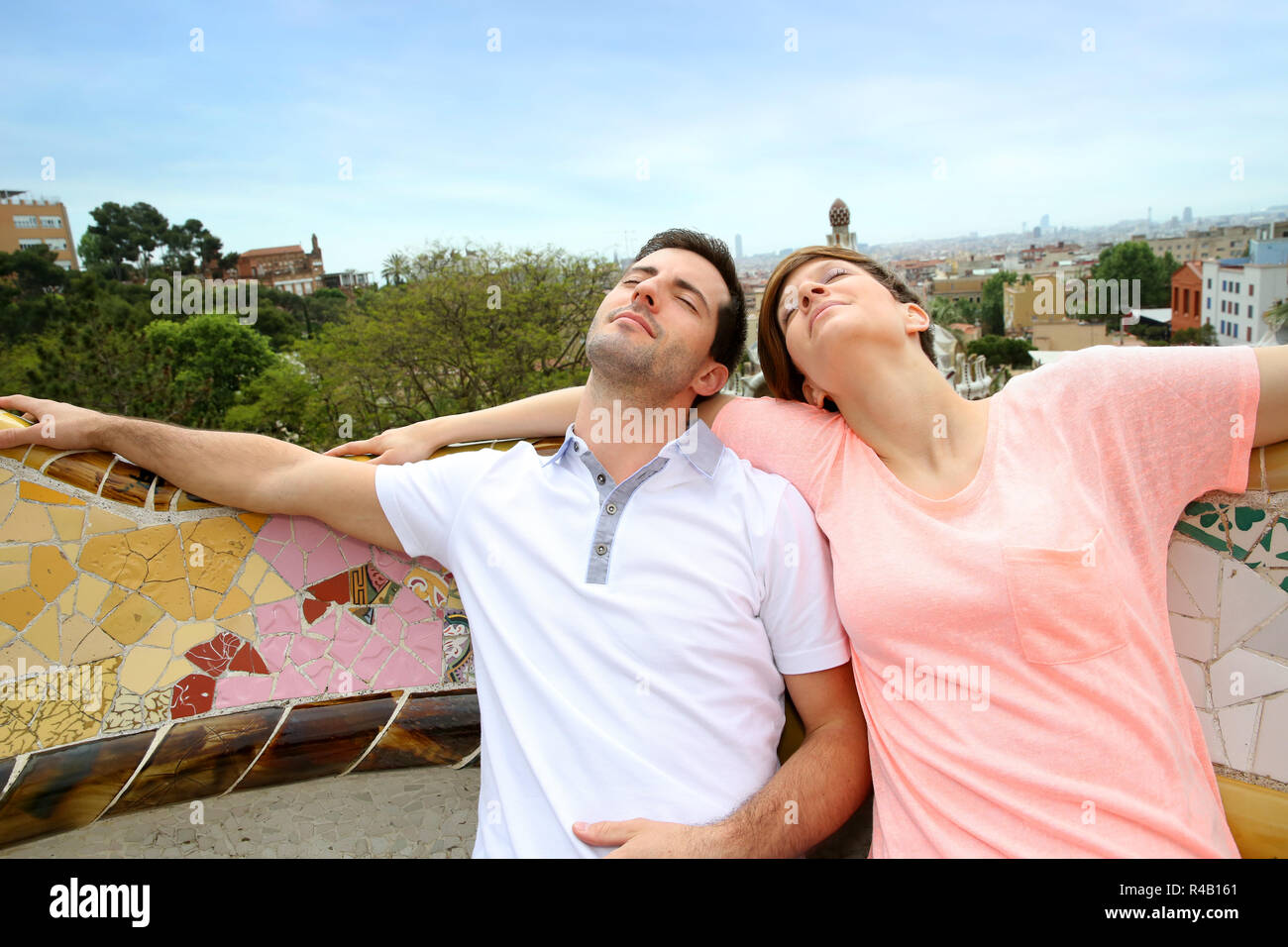 Couple Of Tourists Relaxing On Guell Park Bench Stock Photo