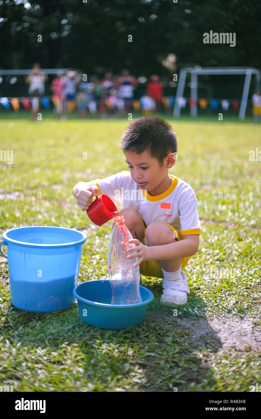 Children compete in fillthebottle game during their kindergarten sports day Stock Photo Alamy