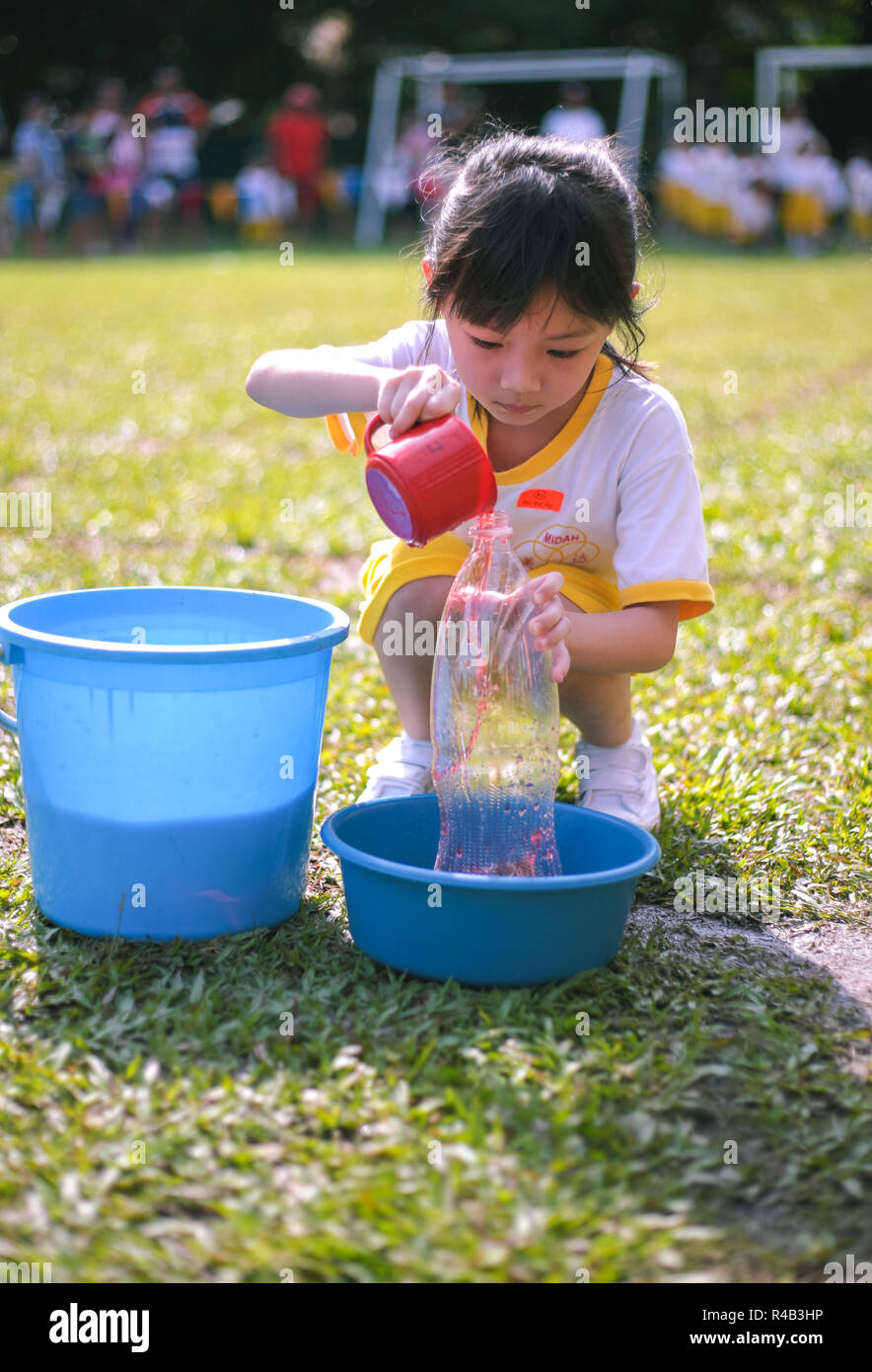 Children compete in fillthebottle game during their kindergarten
