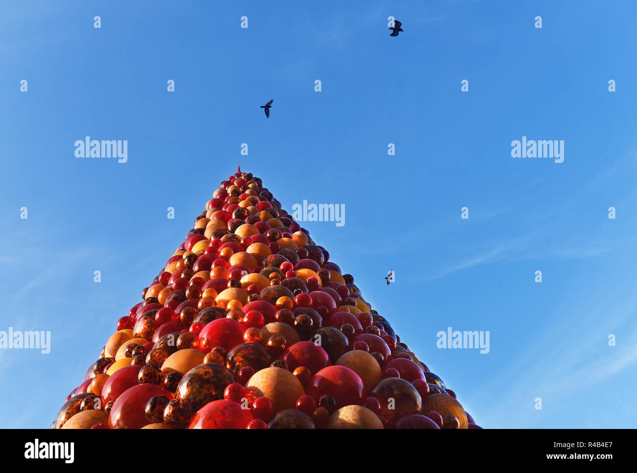 Christmas Tree in Valletta Malta with pigeons flying in blue sky