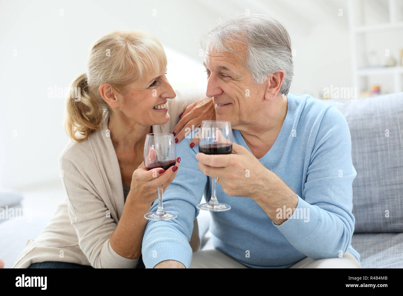 Cheerful senior couple cheering with glass of wine Stock Photo - Alamy