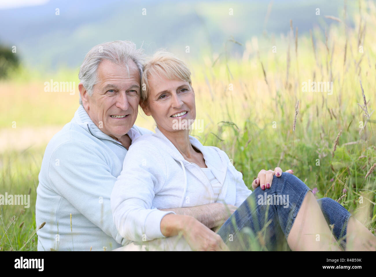 Senior couple relaxing in wild grass field Stock Photo - Alamy