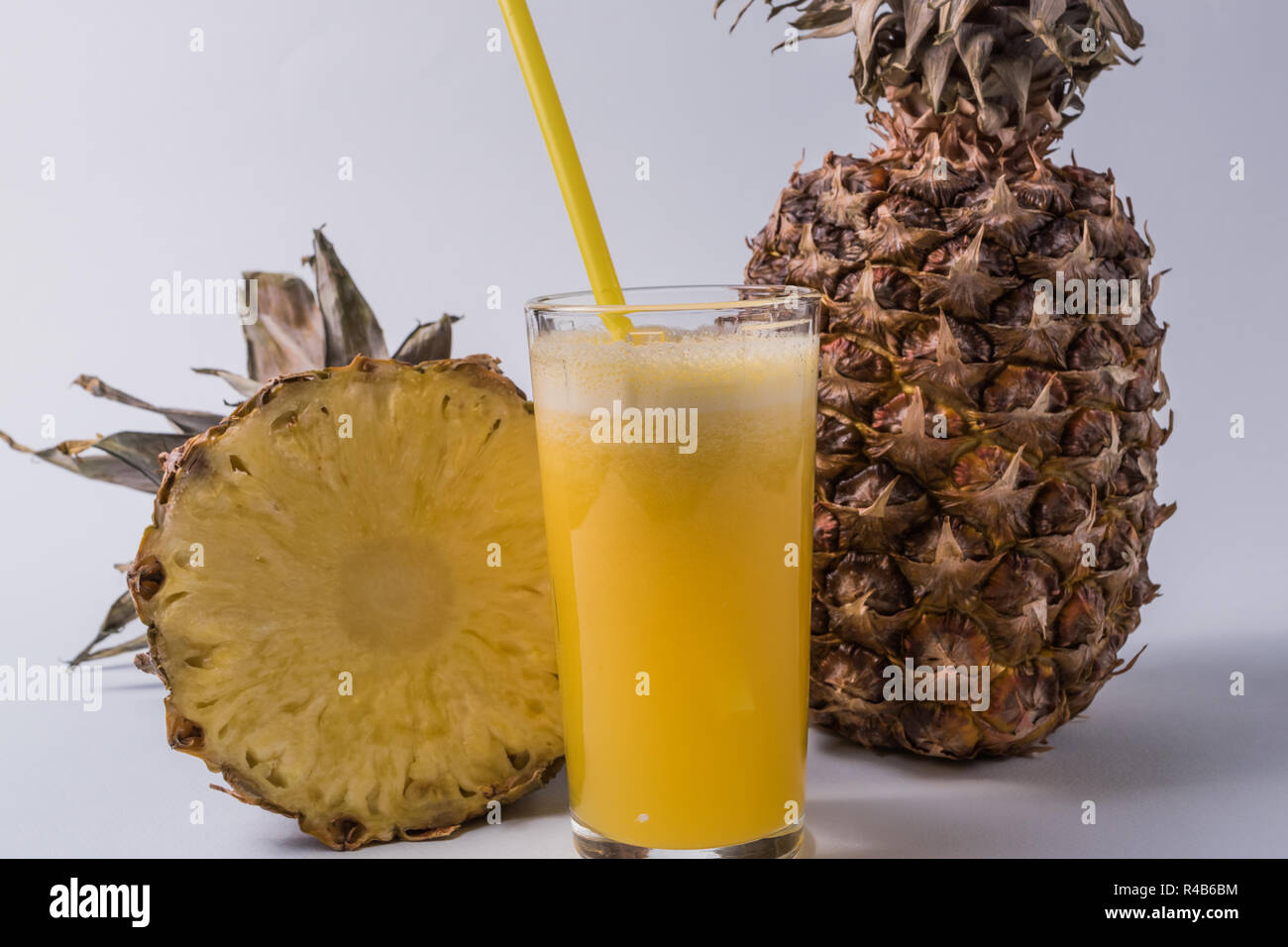 Front view the glass of pineapple juice and pineapple fruit over white ...