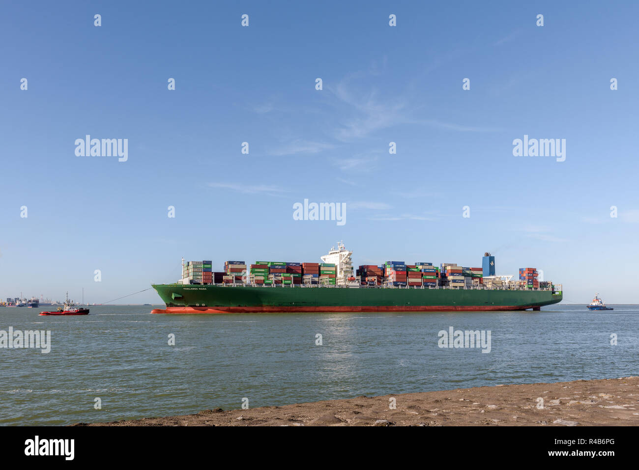 ROTTERDAM, THE NETHERLANDS - FEBRUARY 16, 2018: The large container ship Thalassa Mana is escorted by tugs at its arrival at the Maasvlakte, Port of R Stock Photo