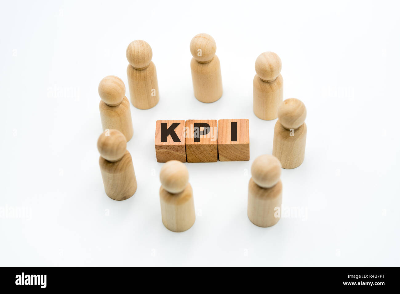 Wooden figures as business team in circle around acronym KPI Key Performance Indicator, isolated on white background, minimalist concept Stock Photo