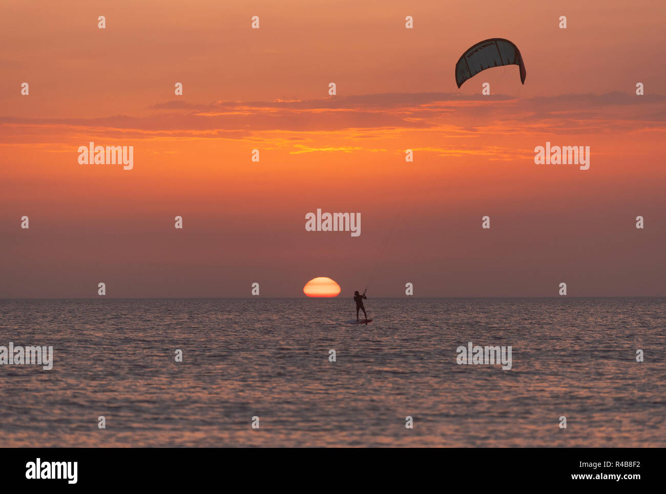 Kitesurfing on a foil at sunset. Tarifa, Costa de la Luz, Cadiz, Andalusia, Spain. Stock Photo