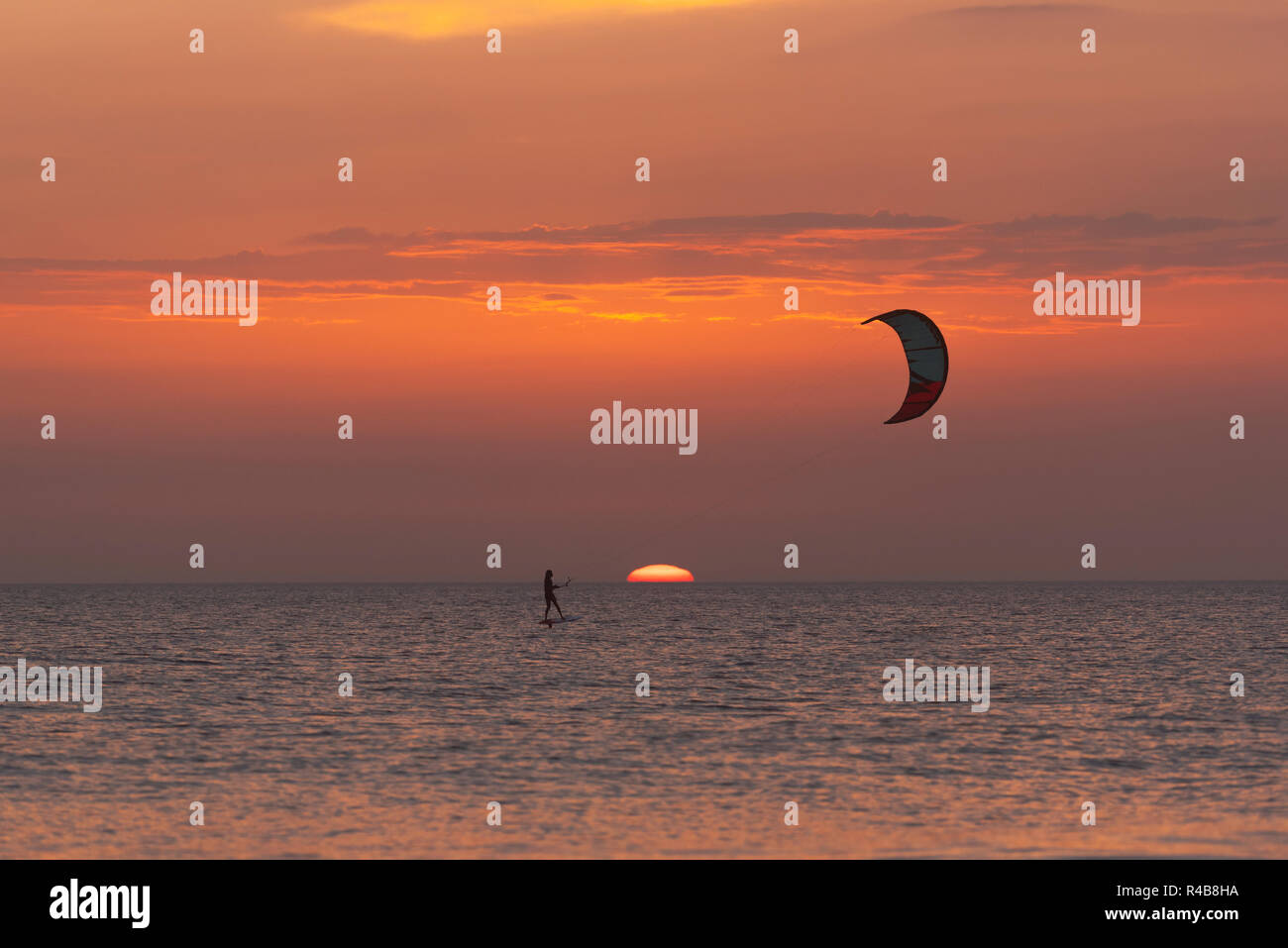 Kitesurfing on a foil at sunset. Tarifa, Costa de la Luz, Cadiz, Andalusia, Spain. Stock Photo