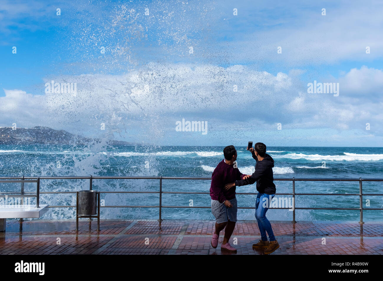 two boys getting wet with wave in playa de las canteras, las palmas de gran canaria, spain Stock Photo
