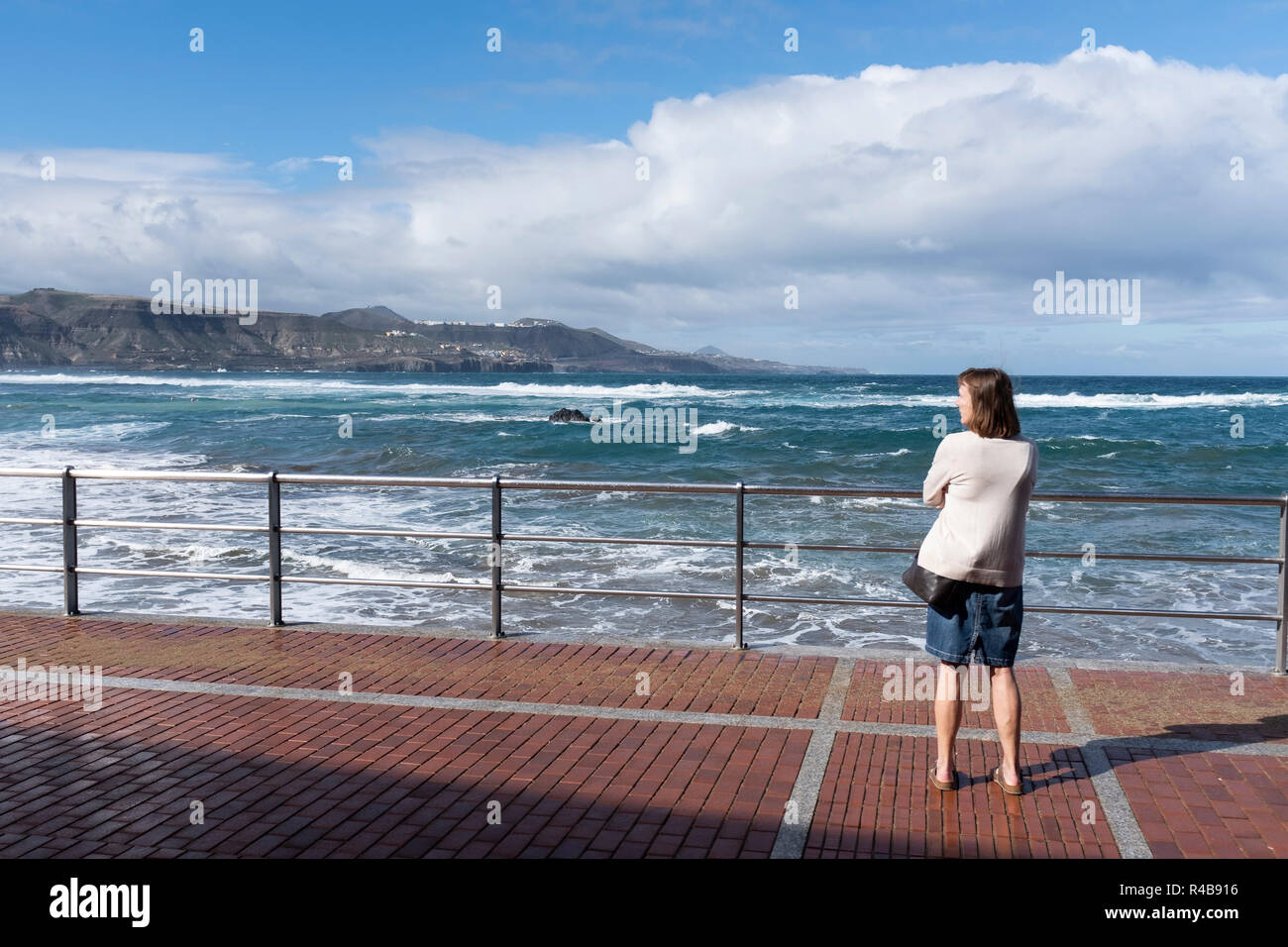 a woman enjoys the landscape of the beach of Las Canteras in LAs Palmas de gran Canaria, Spain. Stock Photo