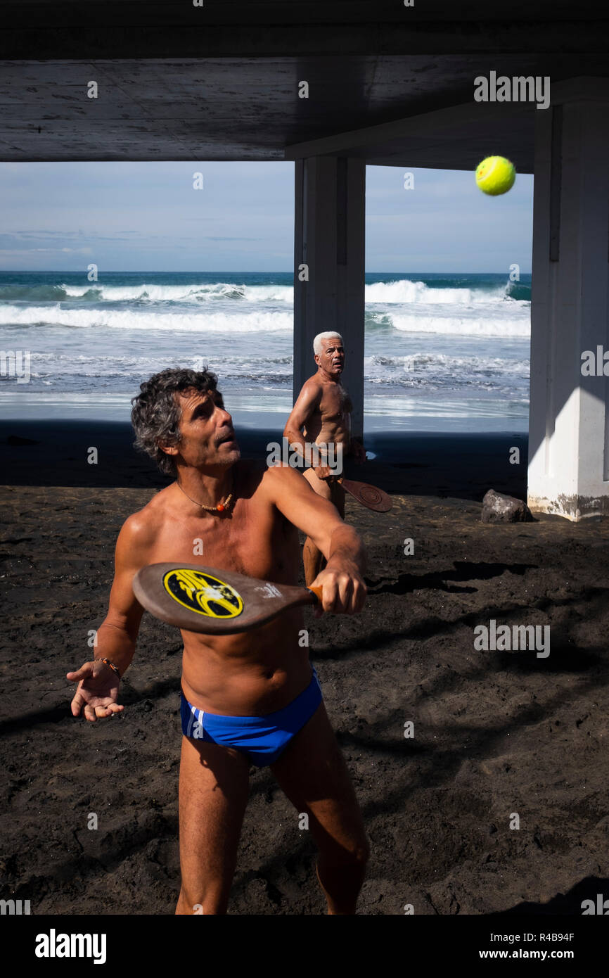 A man playing rackets on the beach Stock Photo