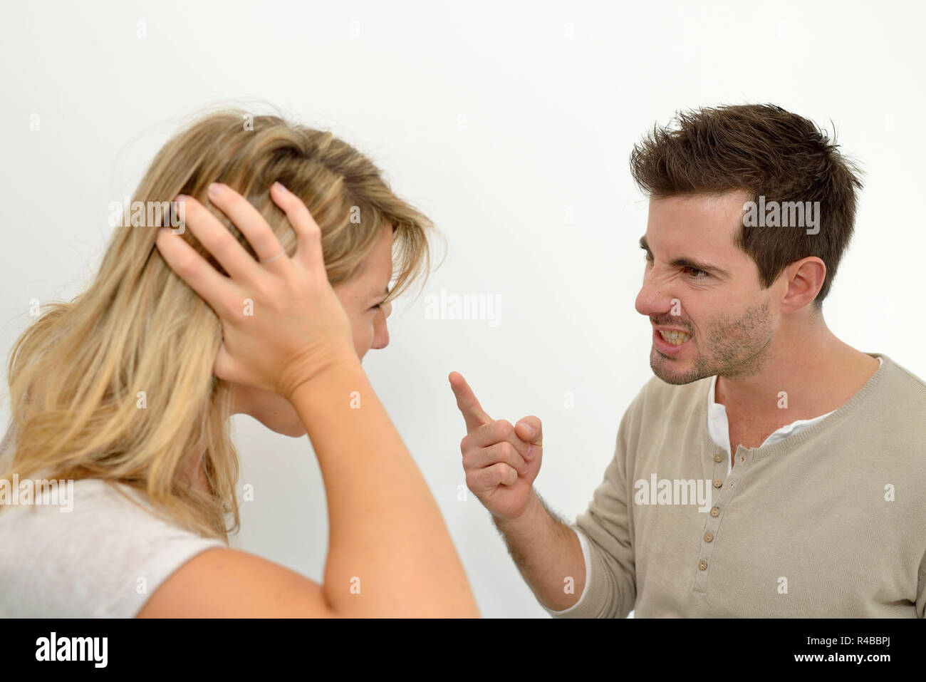 Man being angry at woman and using violence Stock Photo