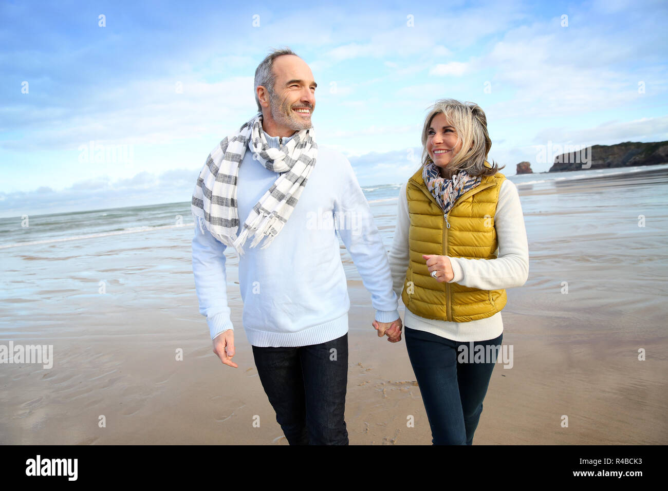 Cheerful senior people walking on the beach Stock Photo