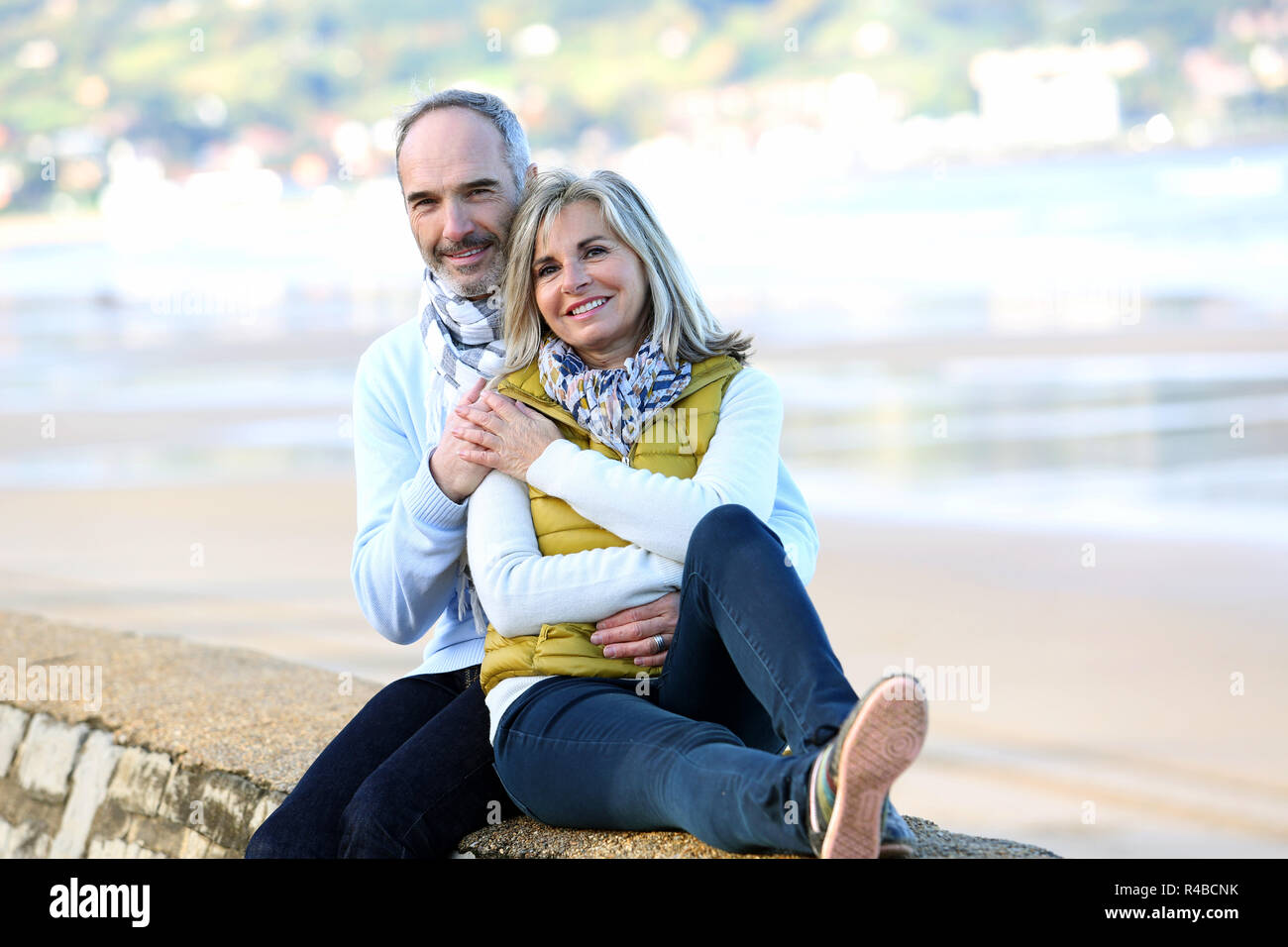Senior couple sitting by the beach Stock Photo - Alamy