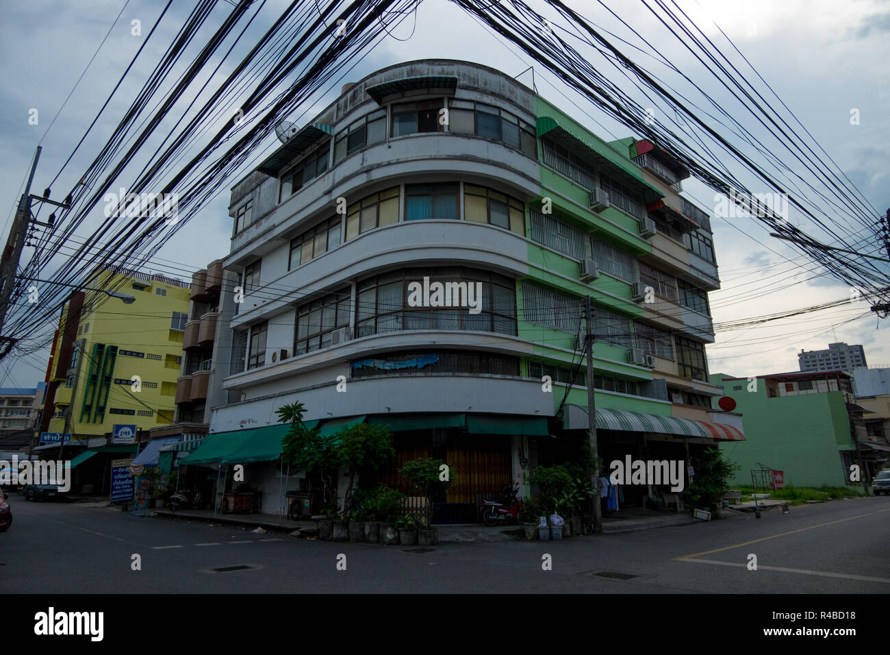 Power lines dominate the skyline in front of an Art Deco style building in Hat Yai, Thailand. Stock Photo