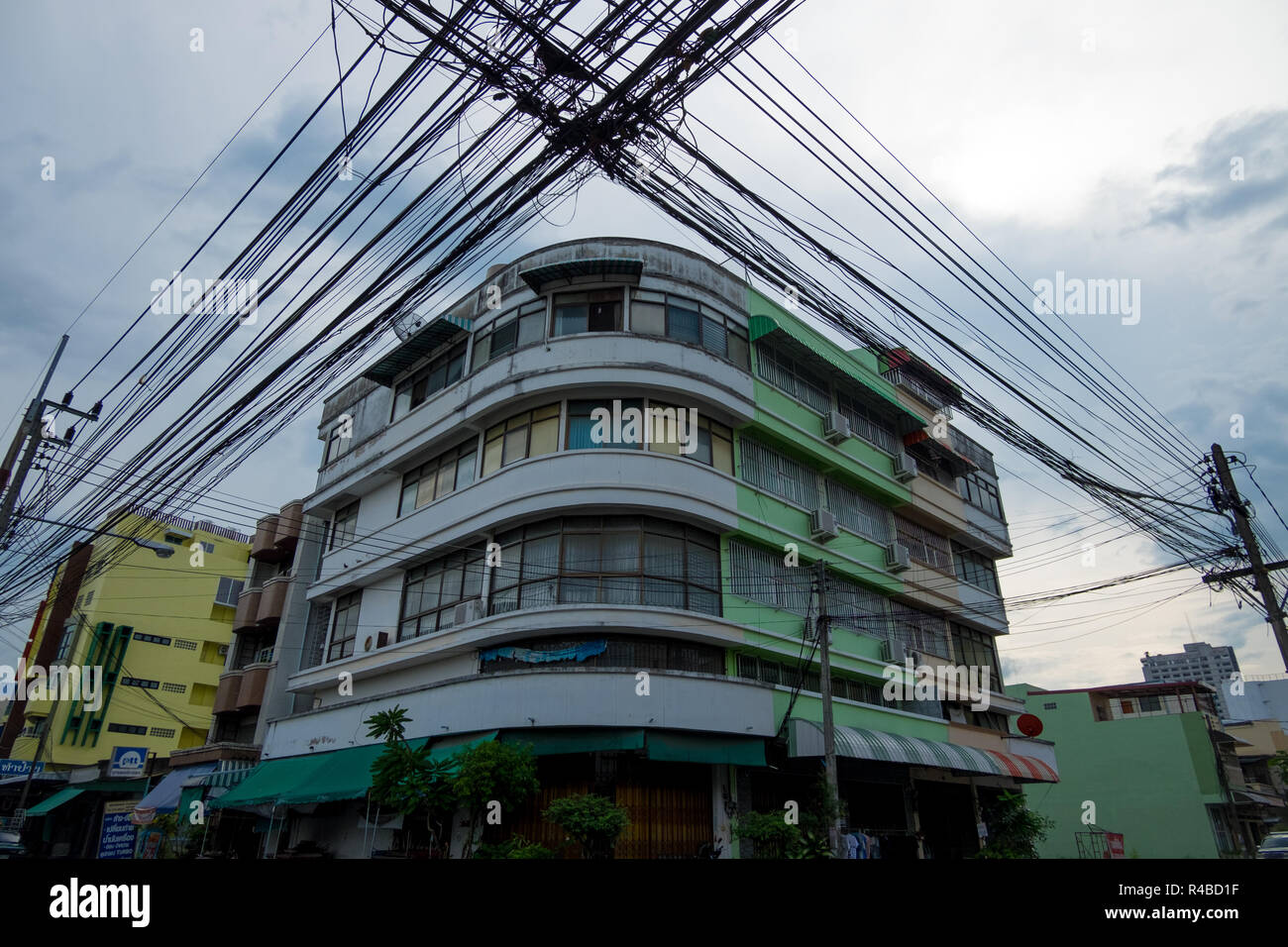 Power lines dominate the skyline in front of an Art Deco style building in Hat Yai, Thailand. Stock Photo