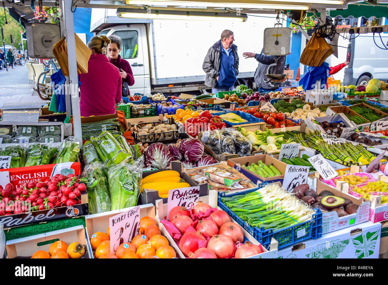 People buying fruits and vegetables at market stall in Portobello Road