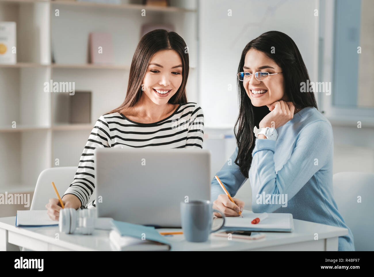 Interior designers. Two appealing pleasant skillful interior designers feeling creative while working on new project Stock Photo