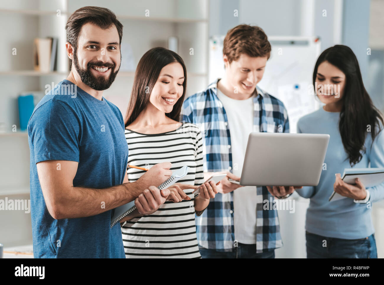 Managers with notebooks. Four promising managers holding their