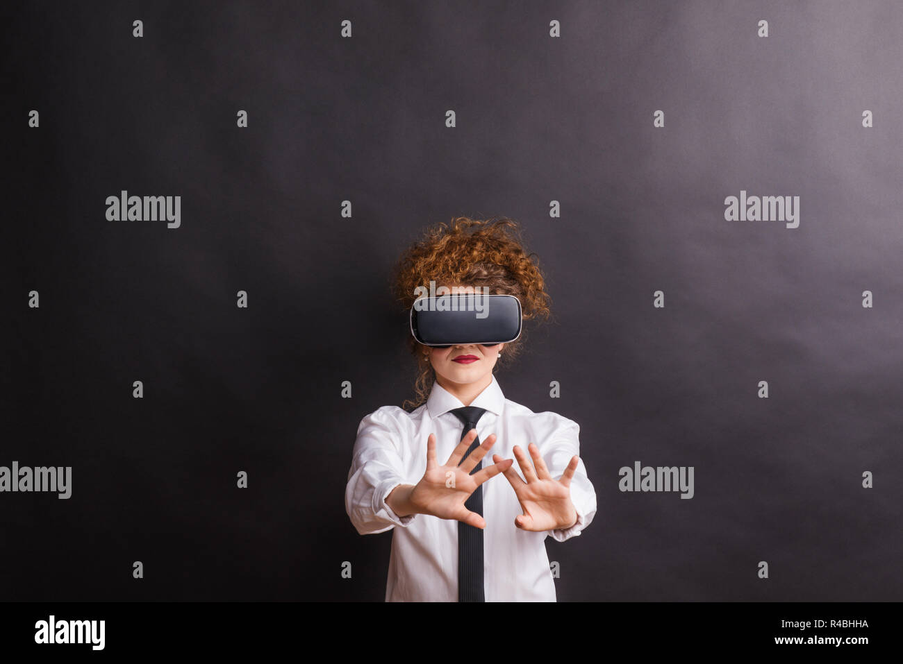 Portrait of a young woman with virtual reality goggles in a studio. Stock Photo