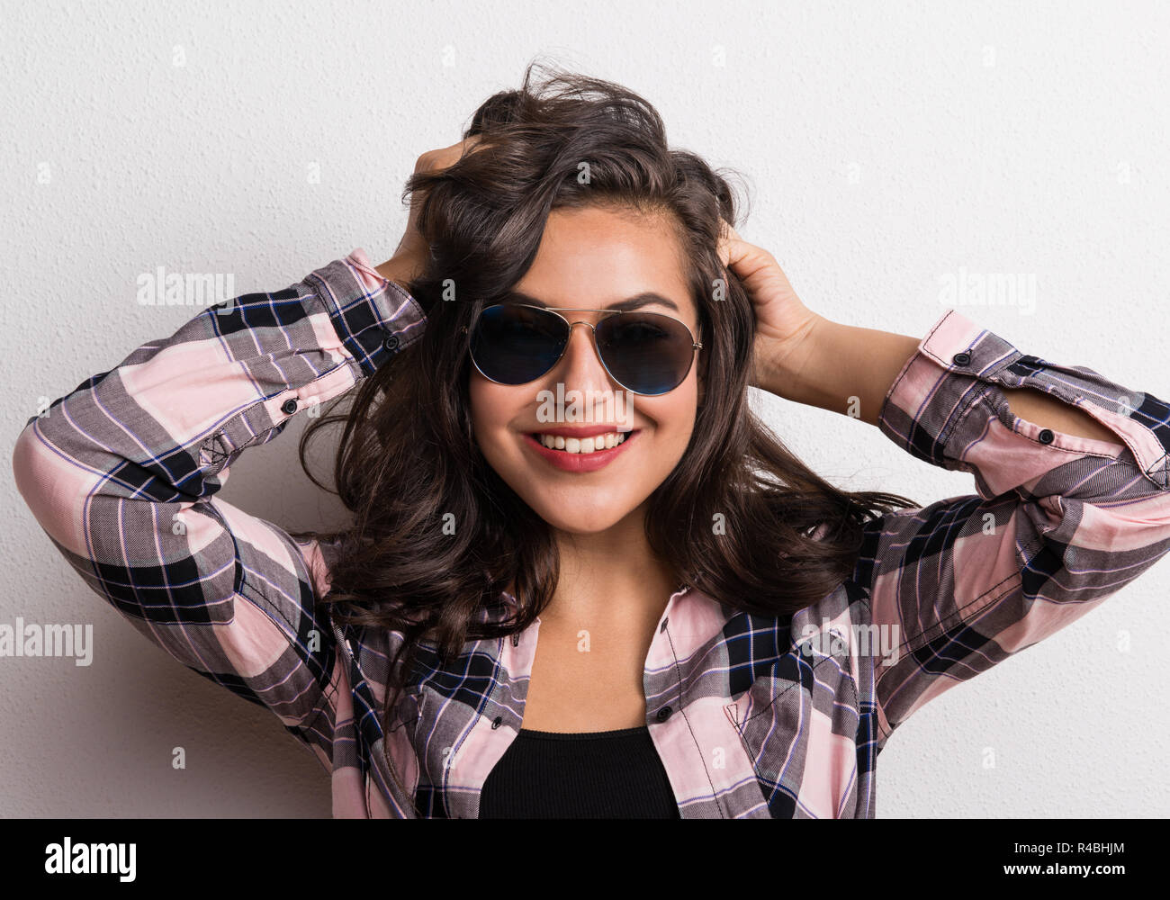 Young beautiful happy woman with sunglasses in studio. Stock Photo