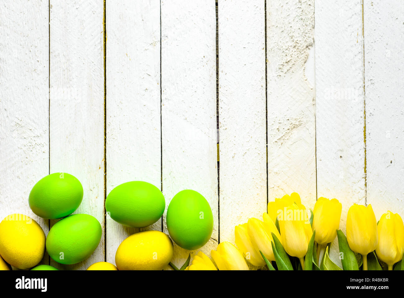 Wooden background with spring easter eggs and tulips on table, top view ...