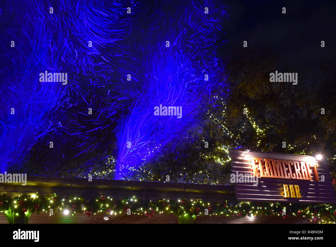 Orlando, Florida. November 19, 2018. Artificial snow illuminated blue and Flamecraft sign in
