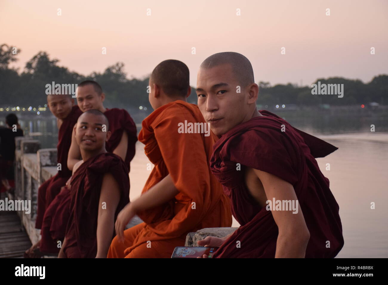 Buddhist monks on U-Bein bridge at sunset in Amarapura, Myanmar Stock Photo