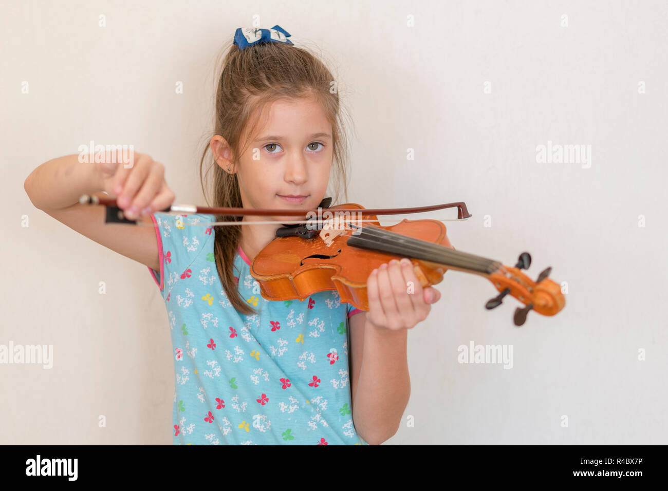 Cute pupil playing violin in classroom at the elementary school. Girl ...