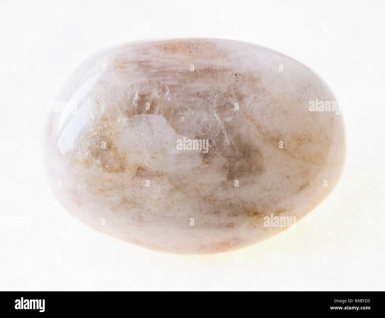 macro photography of natural mineral from geological collection - tumbled albite (moonstone) stone on white background Stock Photo