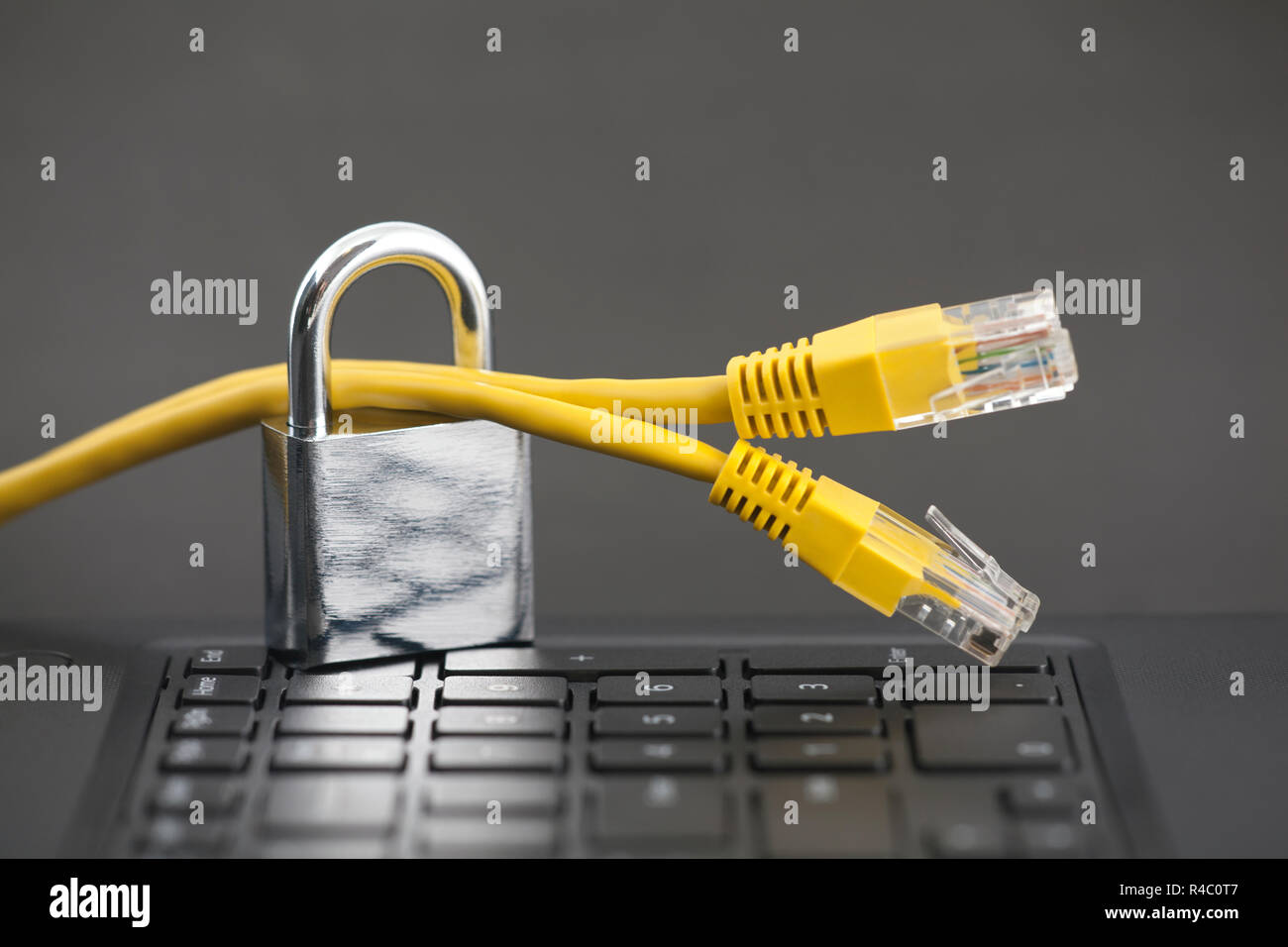 Internet security concept. Padlock with internet cables on computer keyboard Stock Photo