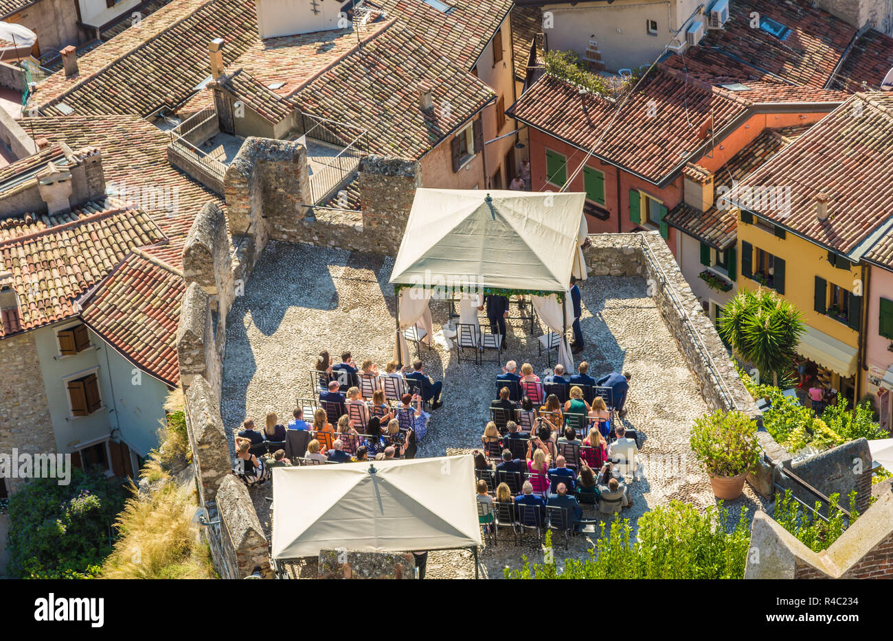 A couple celebrates the outdoor wedding in the Scaliger Castle of the medieval town of Malcesine on Lake Garda, northern Italy. view from above Stock Photo