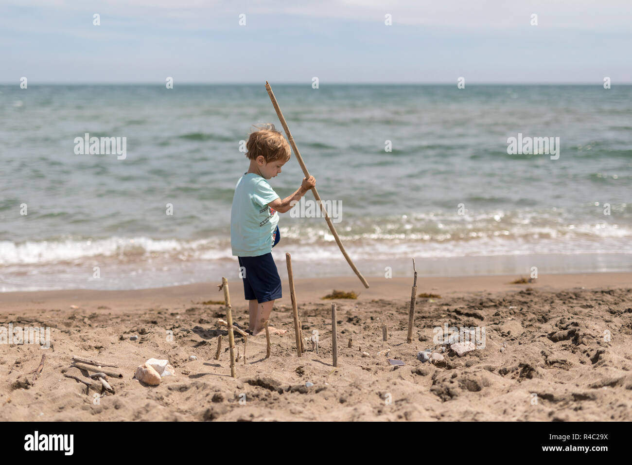 Boy playing at the beach. Scene looks like from the famous movie Lords of the flys. Stock Photo