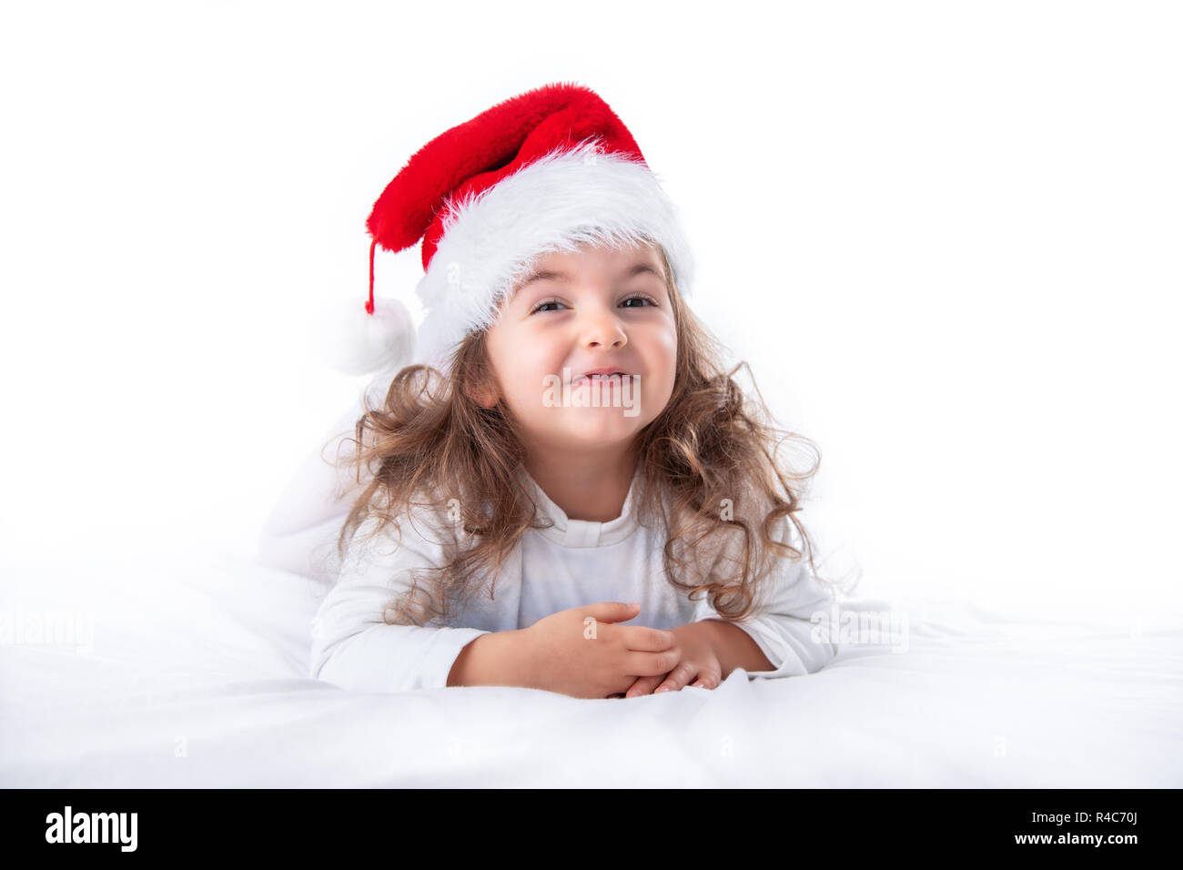 Christmas time, little girl in Santa Claus hat smilling. Stock Photo
