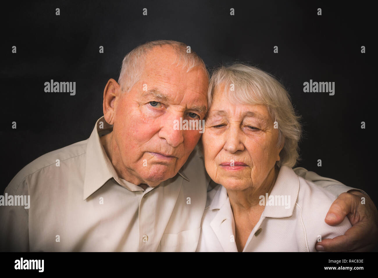 Sad elderly couple on a black background Stock Photo