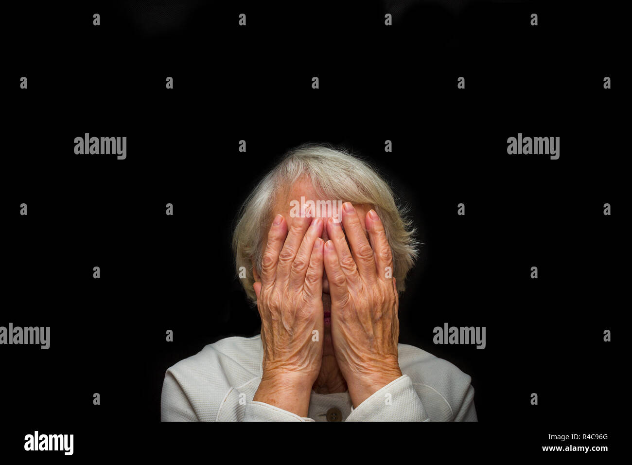 Portrait of an elderly woman with face closed by hands Stock Photo