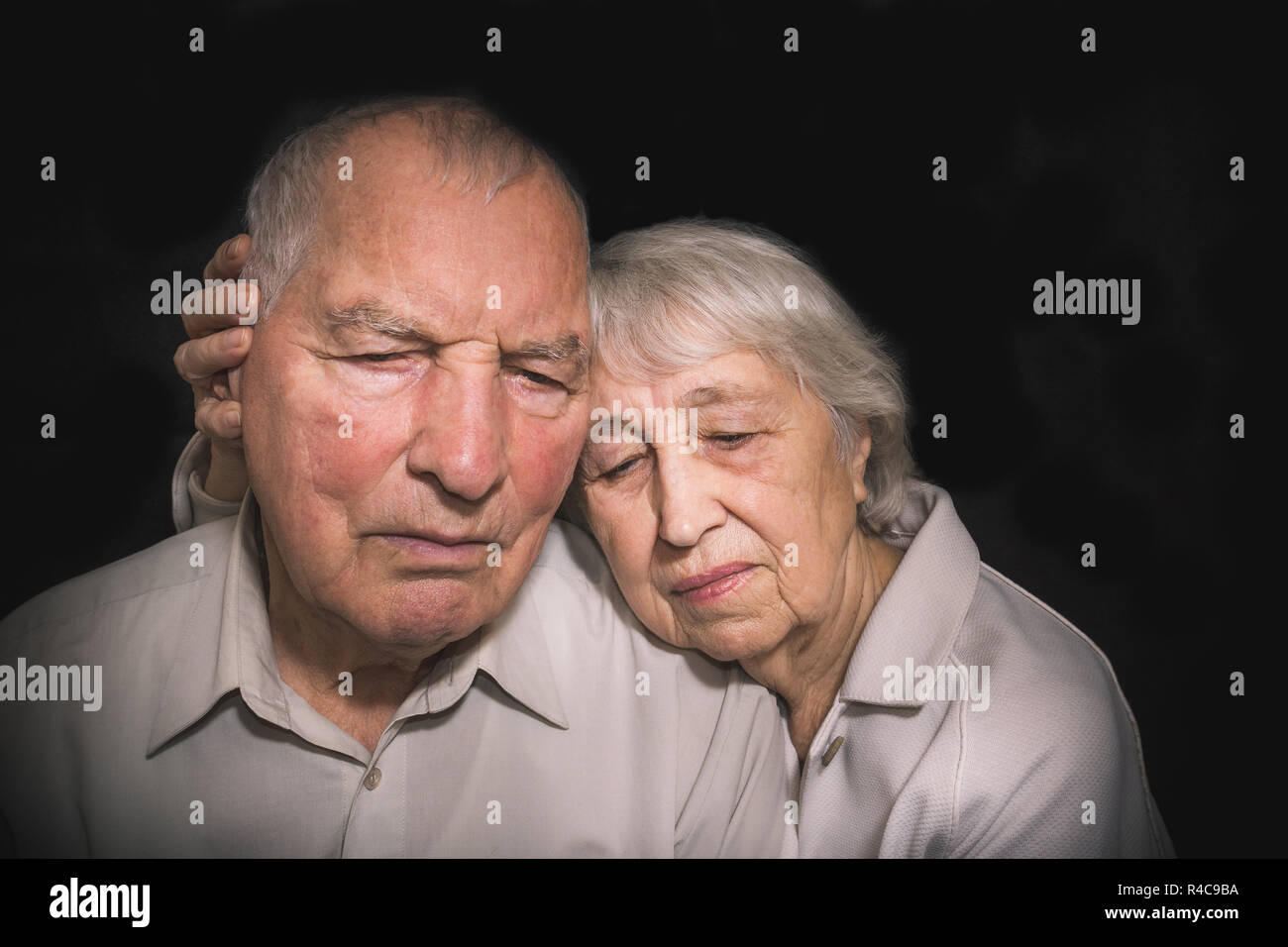 Sad elderly couple on a black background Stock Photo