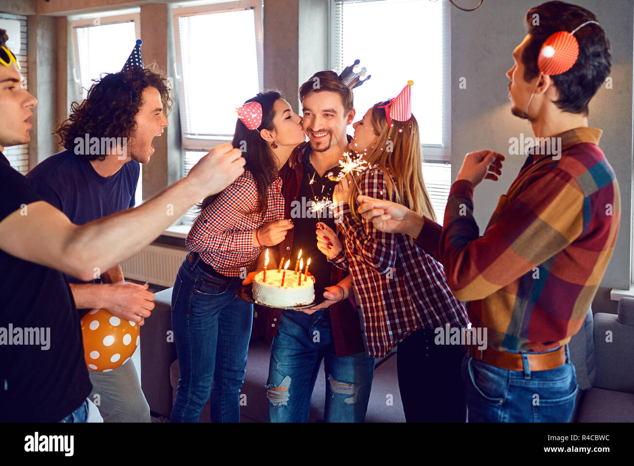 Friends with birthday cake  celebrating birthday at a party. Stock Photo