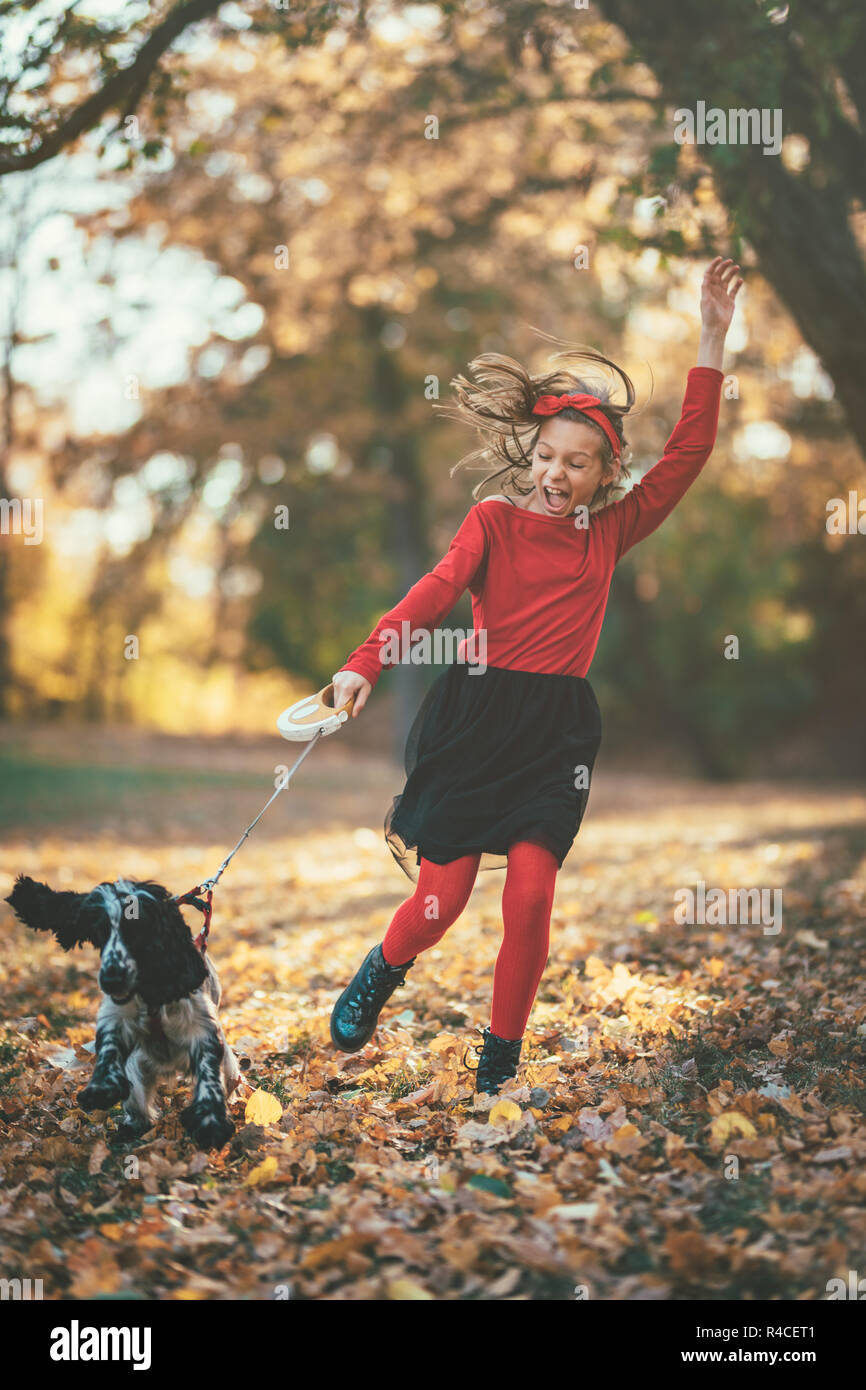 Beautiful happy little girl having fun in the forest with her pet  