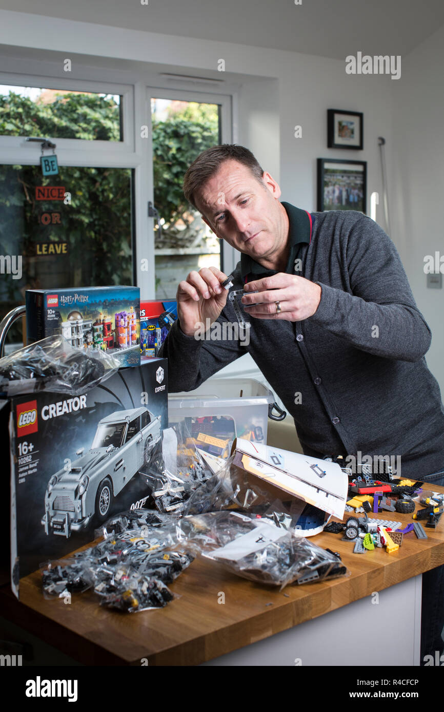Middle aged man building Lego at home in England, as grown ups are admitting to addiction to the brick-building phenomenon, United Kingdom. Stock Photo