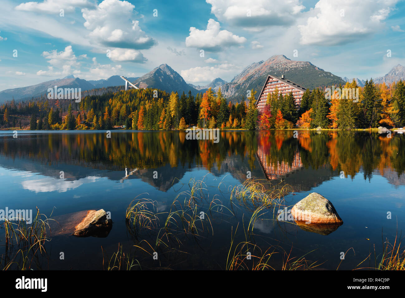 Picturesque autumn view of lake Strbske pleso in High Tatras National Park, Slovakia. Clear water with reflections of orange larch and high mountains Stock Photo